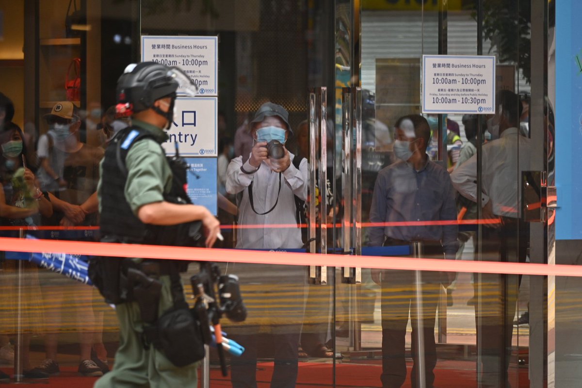 A man trapped inside Sogo Department store takes a photo of the commotion outside.