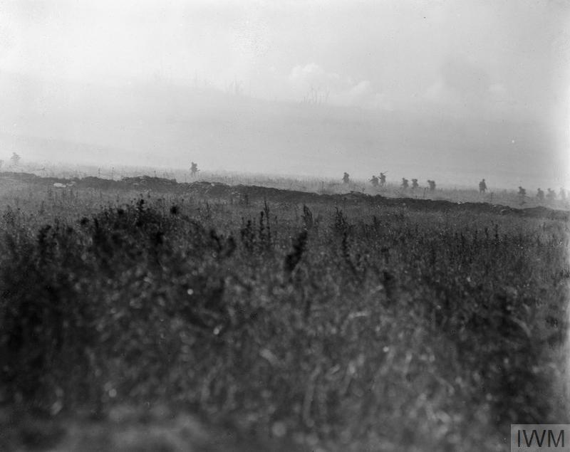A favourite image. 34th Div attack nr La Boisselle. Tall weeds of high summer. Dug earth of a trench. Iron stakes for barbed wire. Men pick their way through, carrying rifles at the slope and trail. Distinctive silhouettes. Distant smoke, bare trees. Q 51 https://www.iwm.org.uk/collections/item/object/205071231