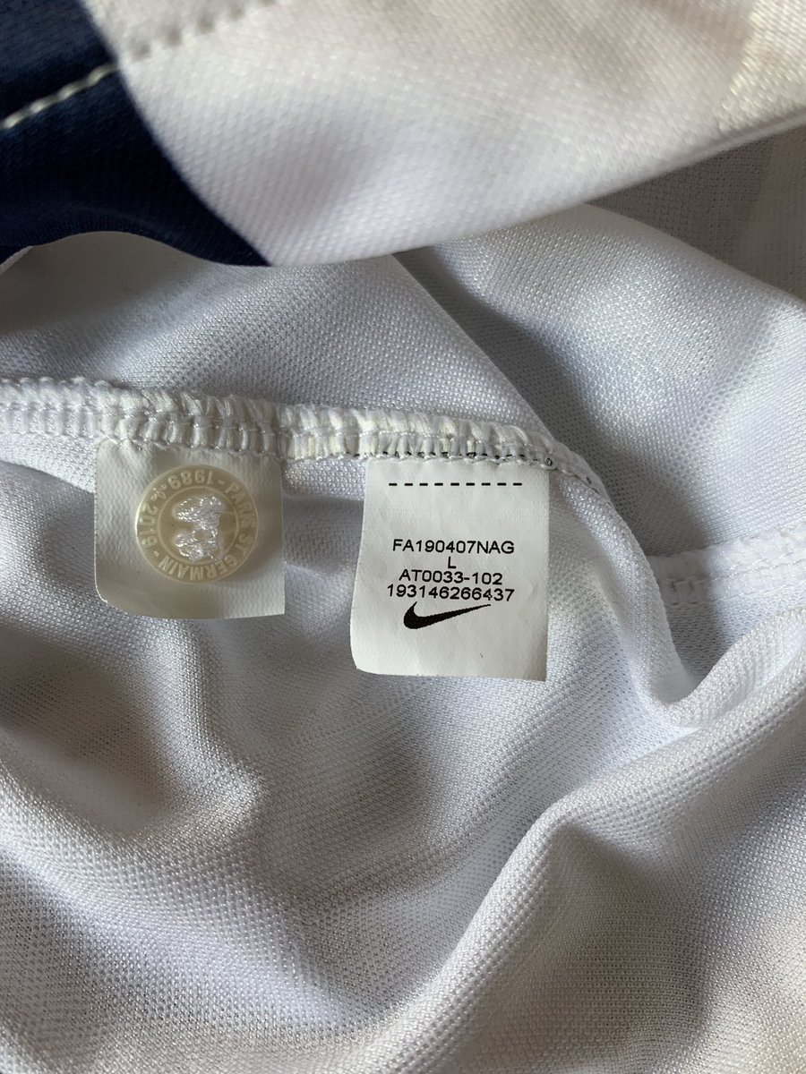 4- À côté de l’étiquette, il y aura un bouton de rechange pour les maillots en possédant un. Vérifiez qu’il y soit, et qu’il soit bien gravé de l’inscription voulue. Certains fabricants de faux mettent un bouton tout simple, parfois même pas de la bonne couleur.