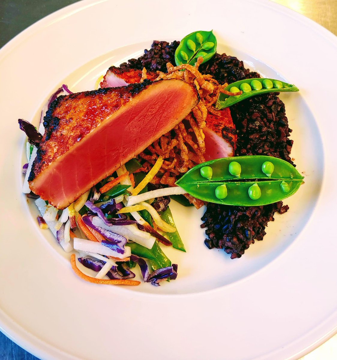 Sriracha powder seared yellowfin, forbidden rice, slaw w/ sugar snap peas, daikon, carrot, and cabbage, fried wonton strips.