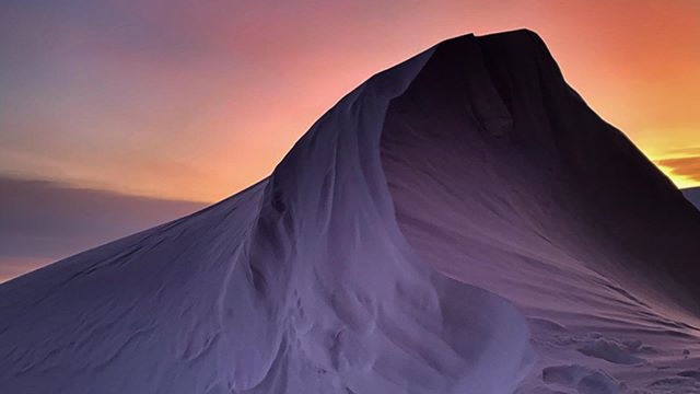 AntarcticReport's tweet photo. Calm after the storm: polar twilight reveals giant snow drifts at Mawson Station after a 5 day blizzard; highest wind speed 137 km/h. The Sun has just started reappearing briefly at noon in the north, following a 2 week absence over the solstice; pic Matt Williams @AusAntarctic https://t.co/e6NhgRDP34