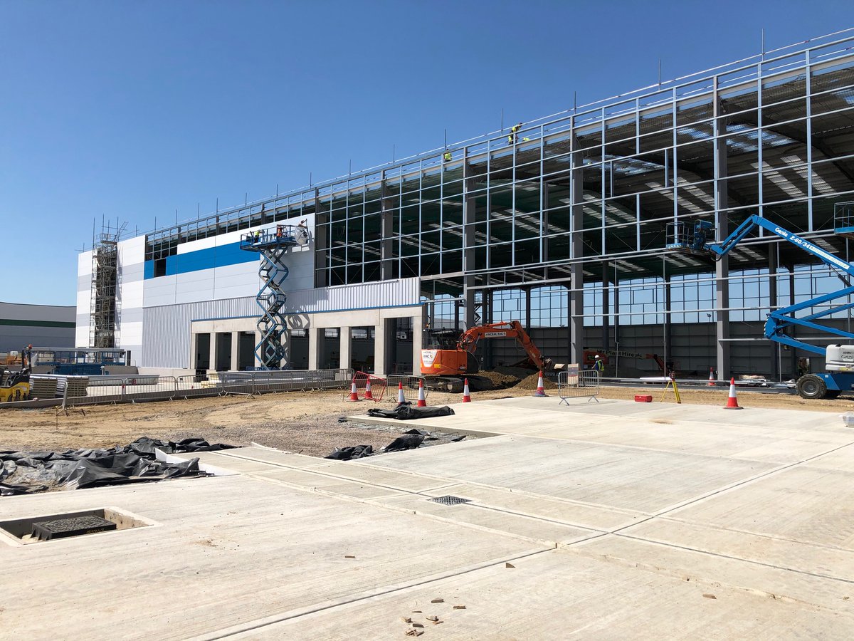 DPWorldUK's tweet photo. Compagnie Fruitiere's  port-centric banana ripening facility at London Gateway Logistic Park is continuing to take shape with the exterior cladding now being applied. #SmartTrade #Logistics https://t.co/Yq1iHQBQQl