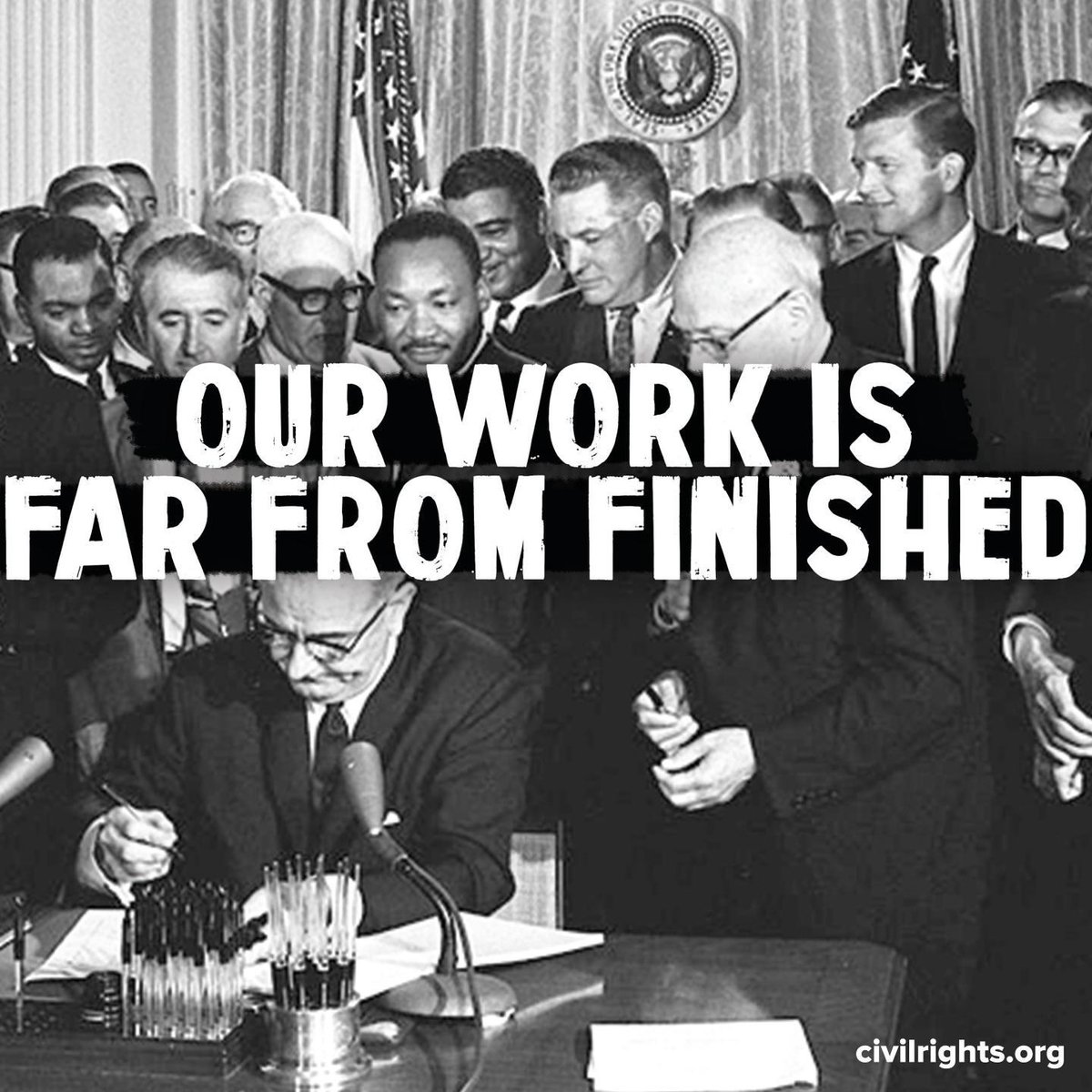 Image of President Johnson signing the Civil Rights Act of 1964, with Dr. King and others watching. On top of the image are the words: "Our work is far from finished."