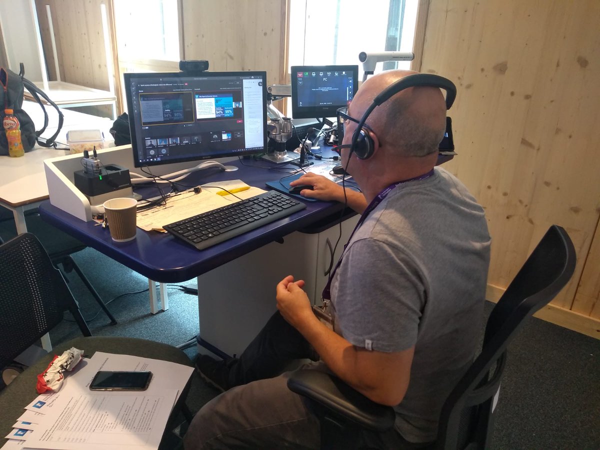 While the presenter and co-host are speaking next door, the producer is queuing up what will be shown on screen next. (5/8)