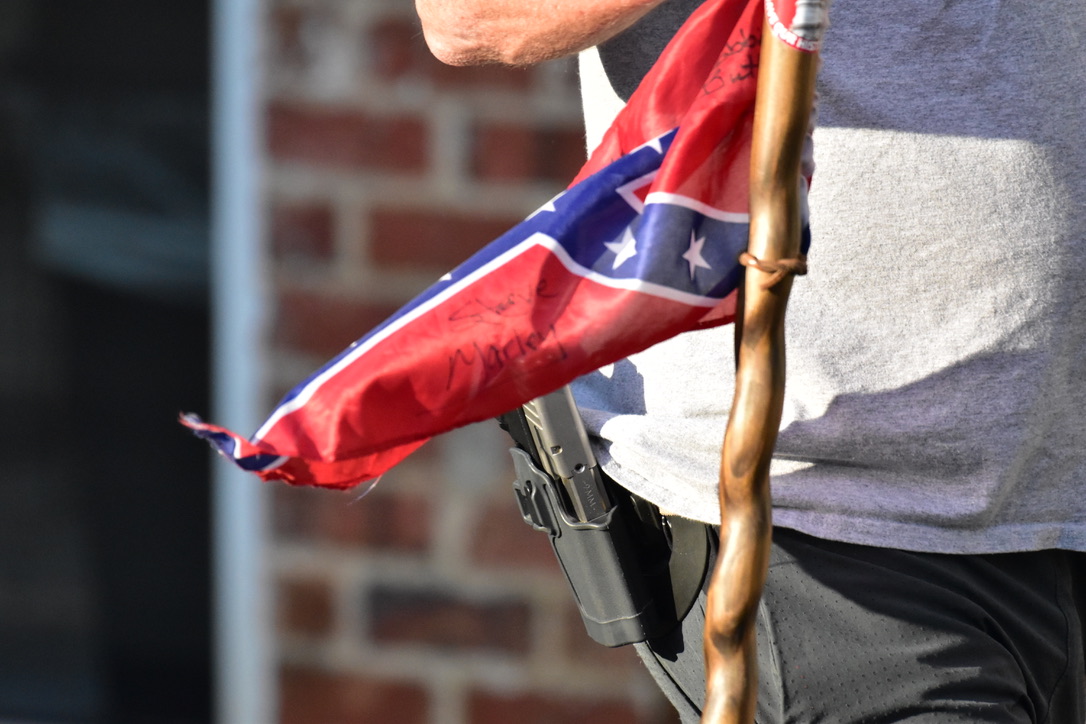 Multiple Confederates were armed and carrying flags in protest. In NC it is illegal for protesters to “willfully or intentionally possess or have immediate access to any dangerous weapons.”
