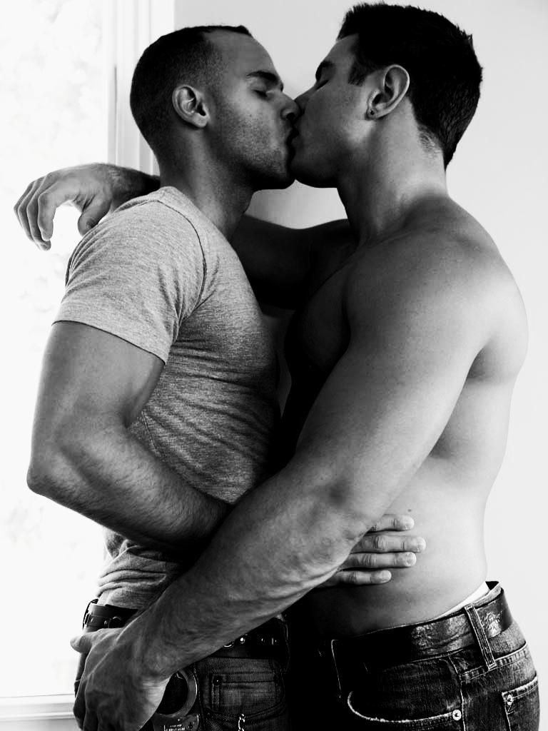 Romantic gay couple kissing in bedroom stock photo