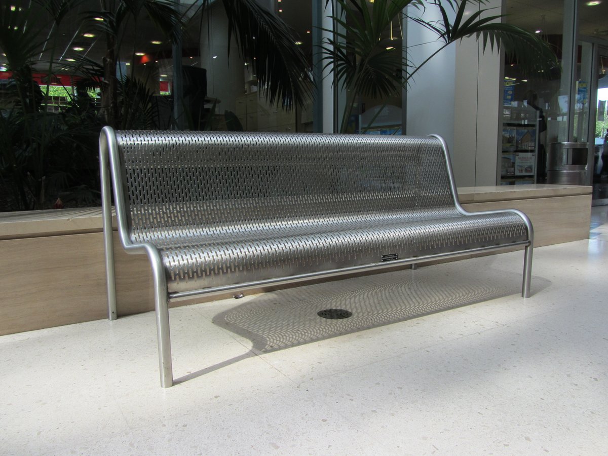 TimSkeltonMK's tweet photo. This week it's the wonderful "Brian Milne" bench - designed to be invisible when viewed from low level: the round holes were changed to slots because children were getting their fingers stuck - still some  around though.  A wooden slatted version was designed for parks. https://t.co/s6YtZ6q6D7