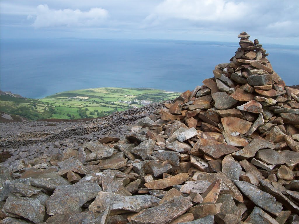 Tre'r Ceiri sits on a steeply-sloping site, its summit occupied by a large early Bronze Age burial cairn - quite clearly preserved, and well-respected by those who later built the wider hillfort.