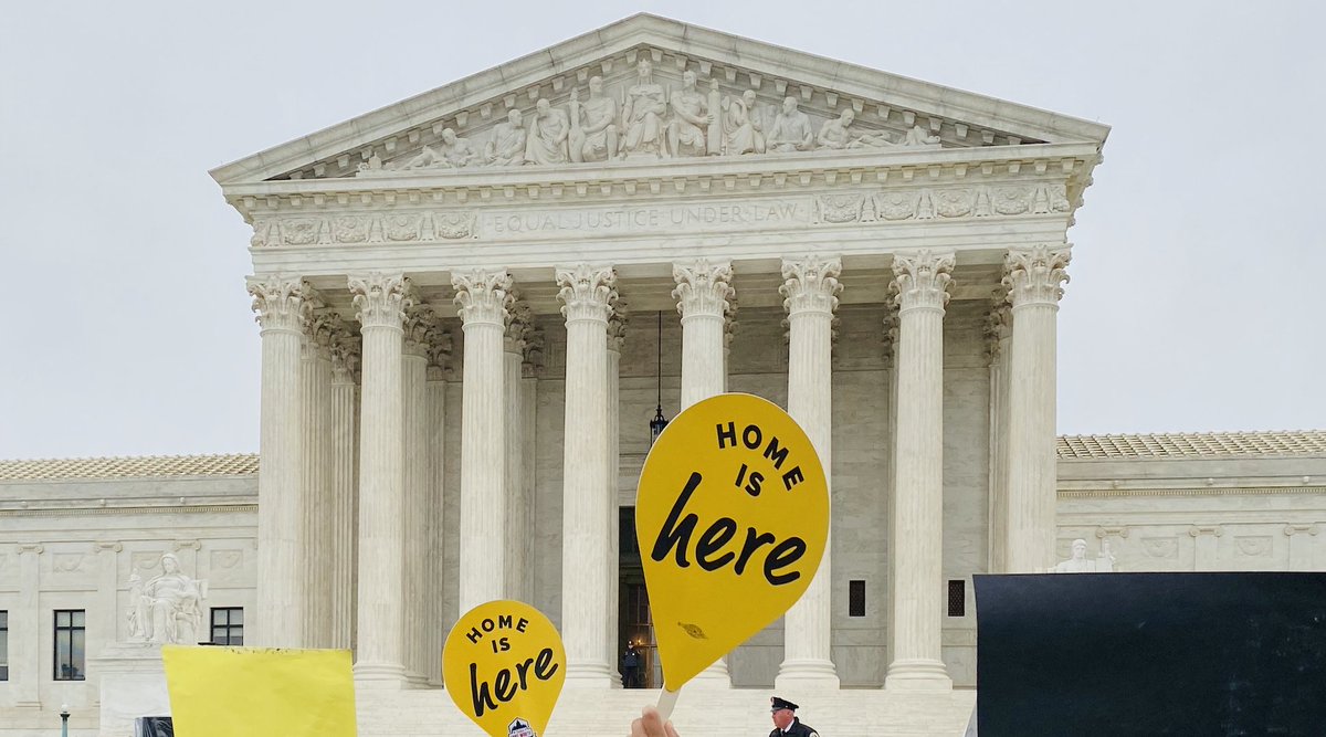 Two signs outside the Supreme Court say "Home Is Here."