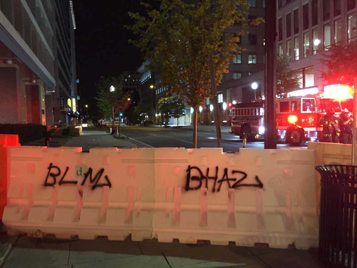 Down on 16th and I, a barrier put up by protesters. Fire department showed up because there was a fire in one of the dumpsters blocking the street. More barricades labeled BHAZ, too.