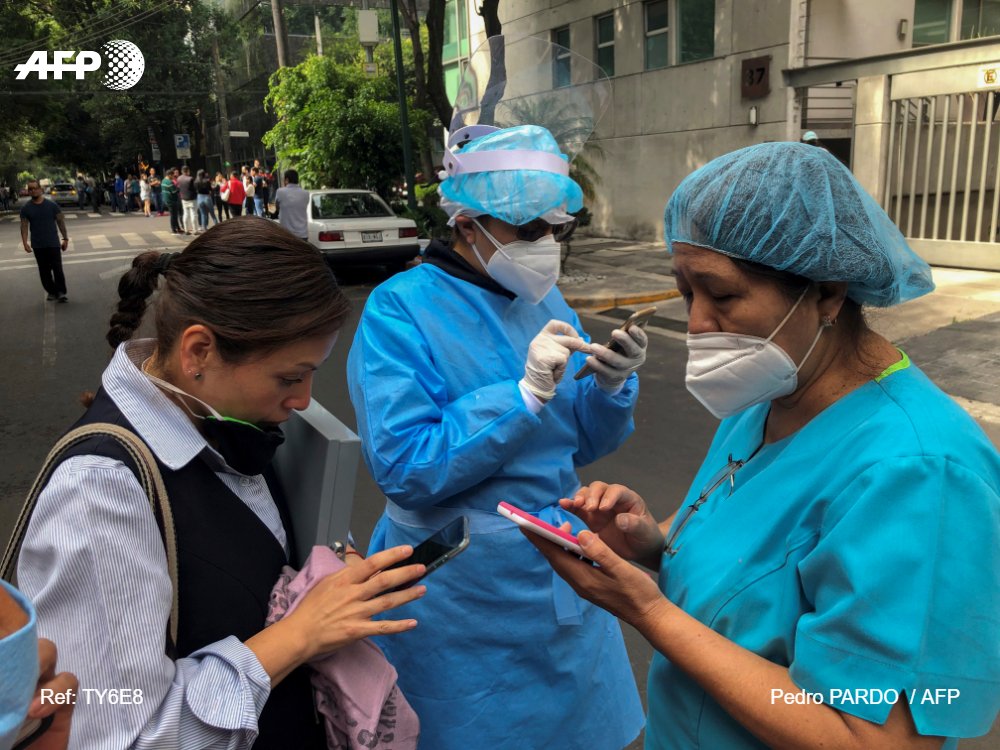 People gather outside in Mexico City after a 7.4-magnitude earthquake was felt there from the epicenter in Crucecita, Oaxaca