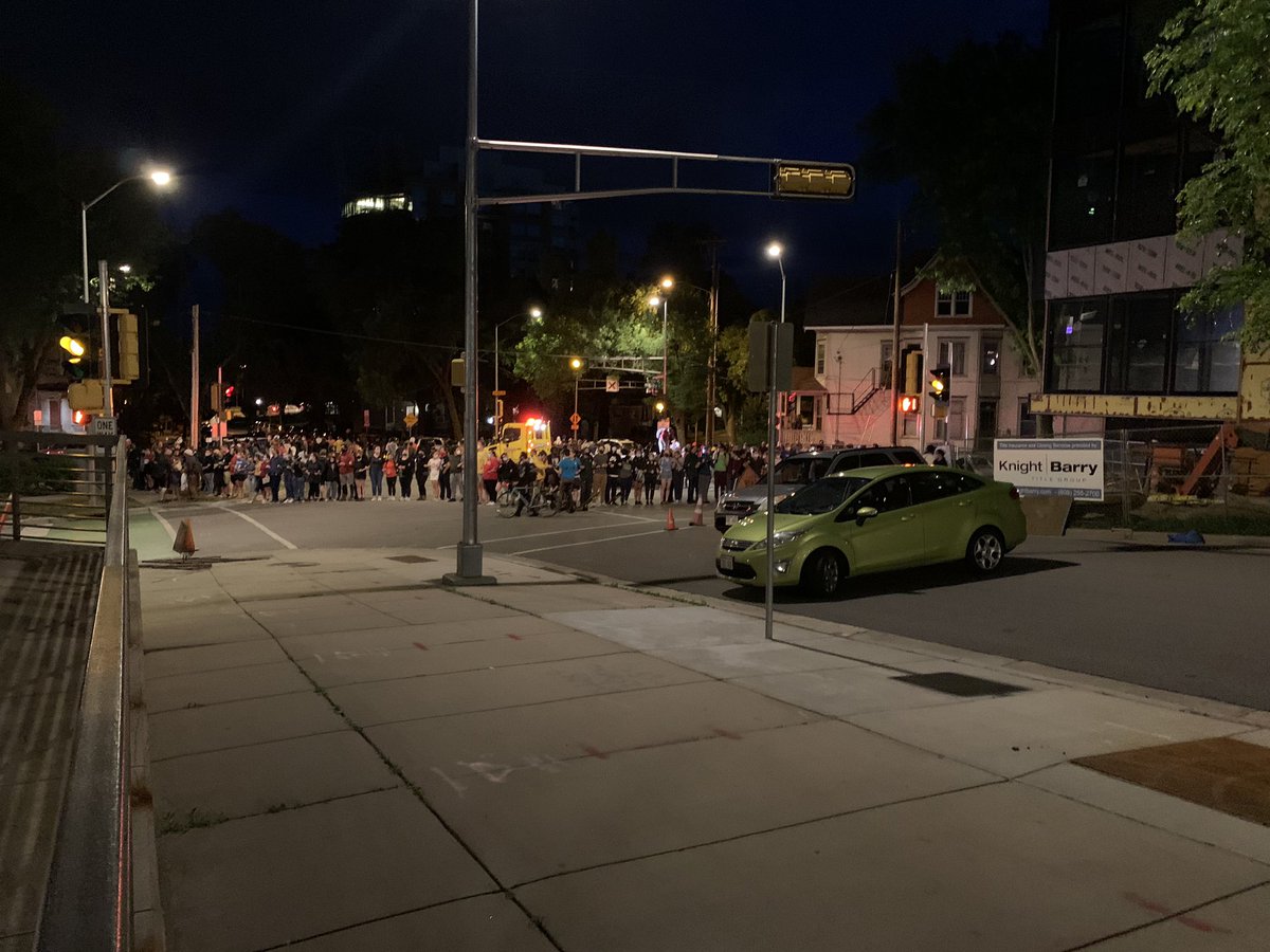 White protesters have formed a barrier around Black protesters (and the tow truck) at the intersection of Henry and Wilson Streets.