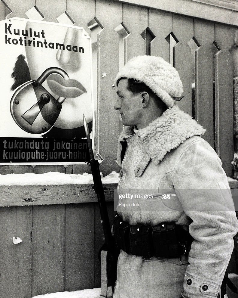 Swedish volunteer soldier examines the famous Finnish Winter War poster: “You belong to the home front - suppress all hearsay, gossip and every rumour!”