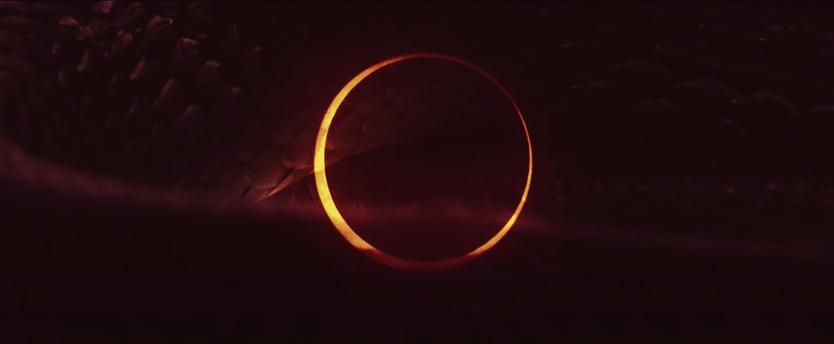 In the prologue, you can see a hint of the giant snake overlaid on the eclipse which also looks like the gold bracelet they wear.