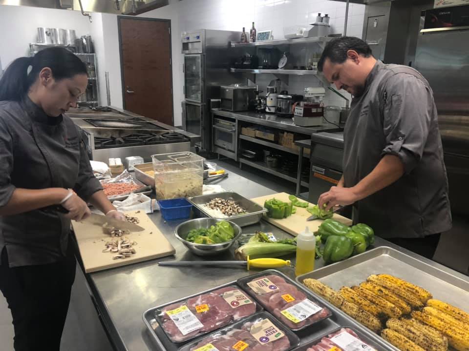 UNLVHospitality's tweet photo. Our chefs Mark &amp; Steph participated in the #24Meals initiative, which provides meals made by local chefs to Las Vegans in need.

Using a box of mystery ingredients, they prepared 24 meals of breaded pork chops on beds of Cajun hash with roasted corn sauce. Way to go, team! https://t.co/r6KcrrR49P