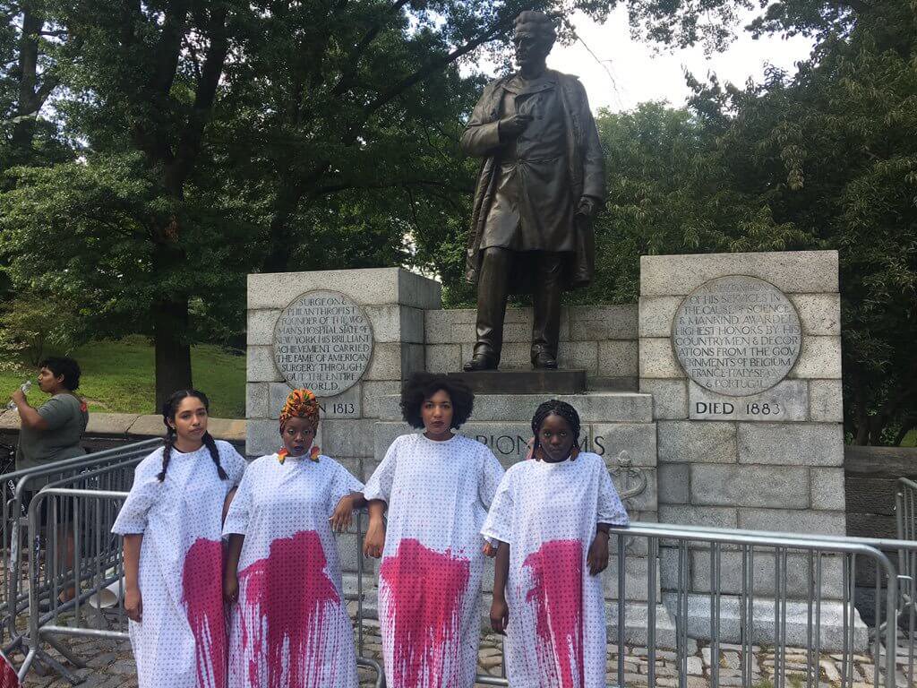 womensart1's tweet photo. Women paint their clothes with red paint in protest against the J. Marion Sims statue in New York, known as the “father of modern gynaecology” he performed painful surgeries on enslaved black women without consent or anaesthesia. The statue was later removed #womensart https://t.co/nBBcfapznk