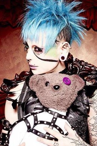 Another good example is Meto, drummer of Mejibray, with a similar persona (not speaking, tweets/blogs in a strange style (iirc all katakana or hiragana)). Both also sometimes carried a stuffed toy as part of their persona - a rabbit for Minpha, and teddy bear for Meto.