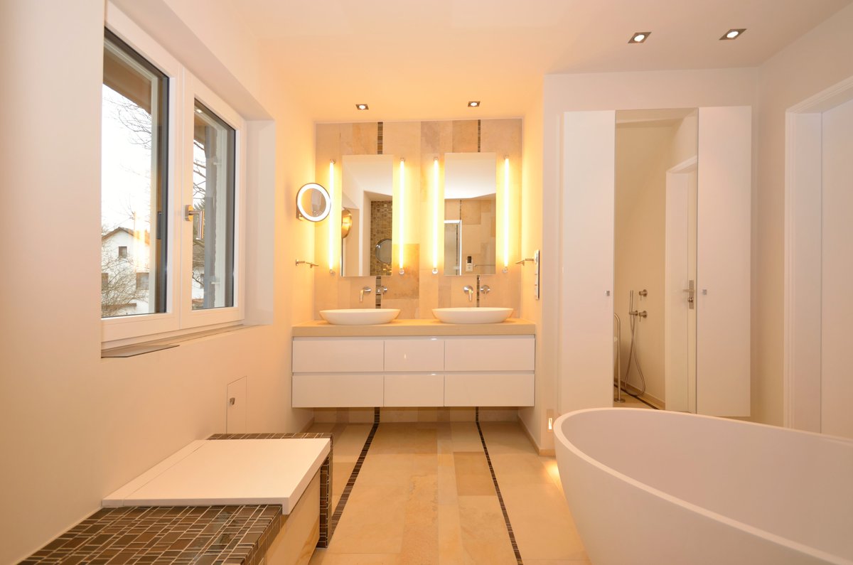 Ein absolutes Paradies für die Augen, ein bronzefarbenes Glasmosaik und der Solnhofer Naturstein mit rauer Oberfläche dominieren dieses Badezimmer.