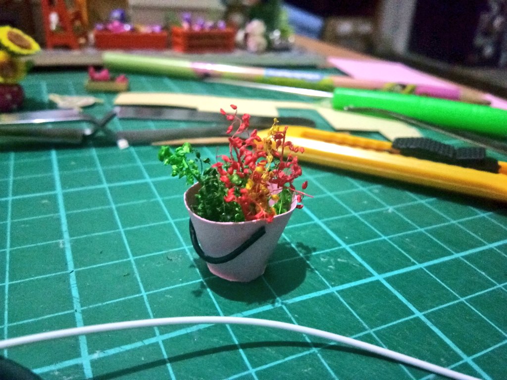 i was supposed to make a tiny silver watering can but i botched that so bad i had to throw it away and improvise something to put in its place so here we havea tiny pink bucket i filled with spare plant parts lmaooo