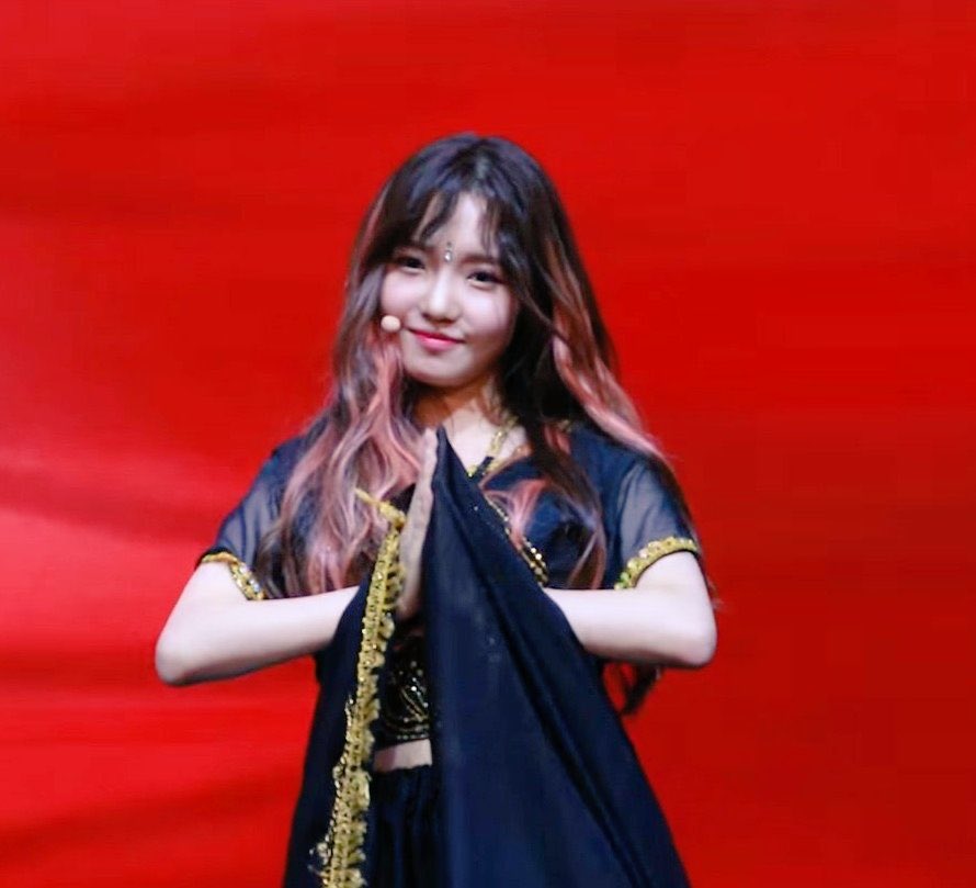 (Fromis_9) Jisun appropriating a mangalasutra ( a jewel given to married women, a bindi and a lehenga while doing mudras and the Namaste hand