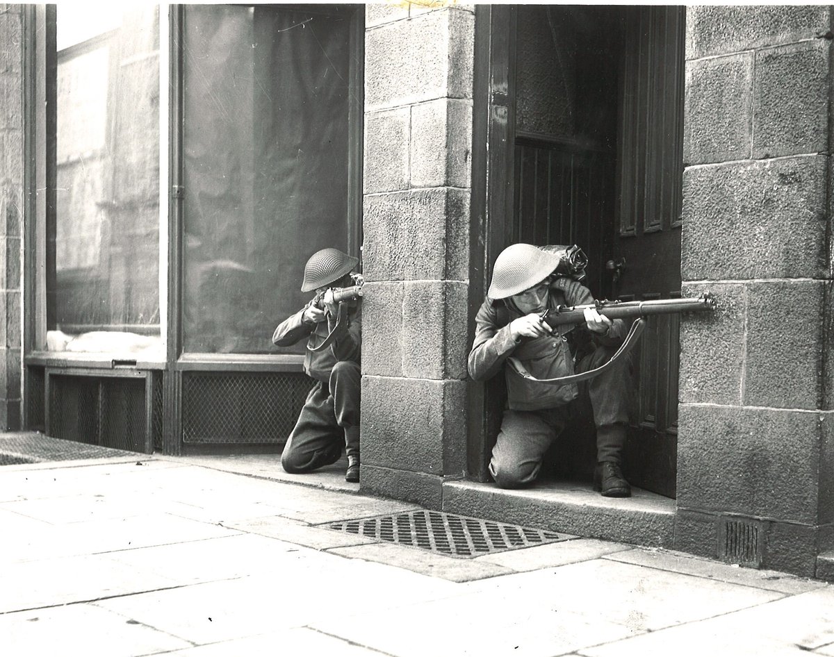 Two pupils of the Aberdeen School of Street Fighting prepare for duty, May 1942.