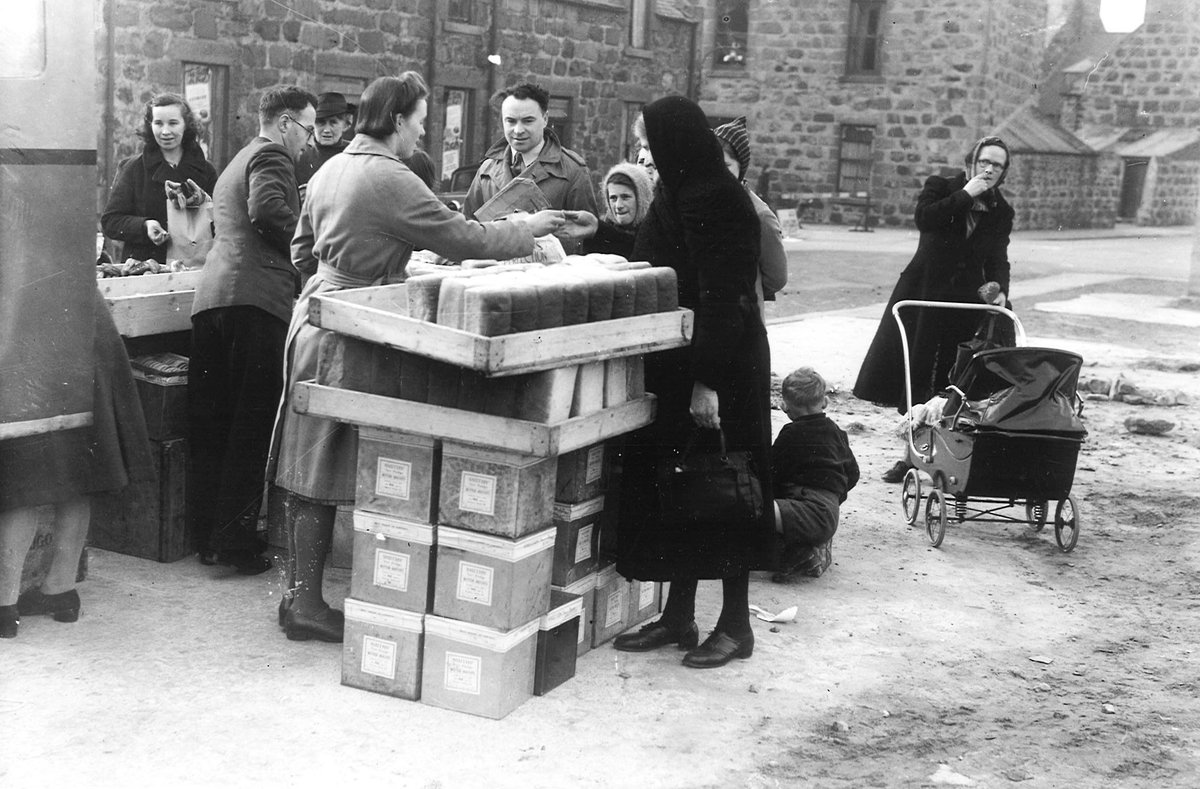 People in Fraserburgh buy bread from the back of a van, September 1941.