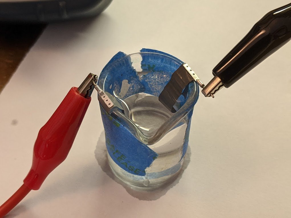 salt water makes a decent electrolyte, so that's what i've filled the beaker with. now, suddenly, we get a *lot* more capacitance--almost as much as the original 0.47uF!