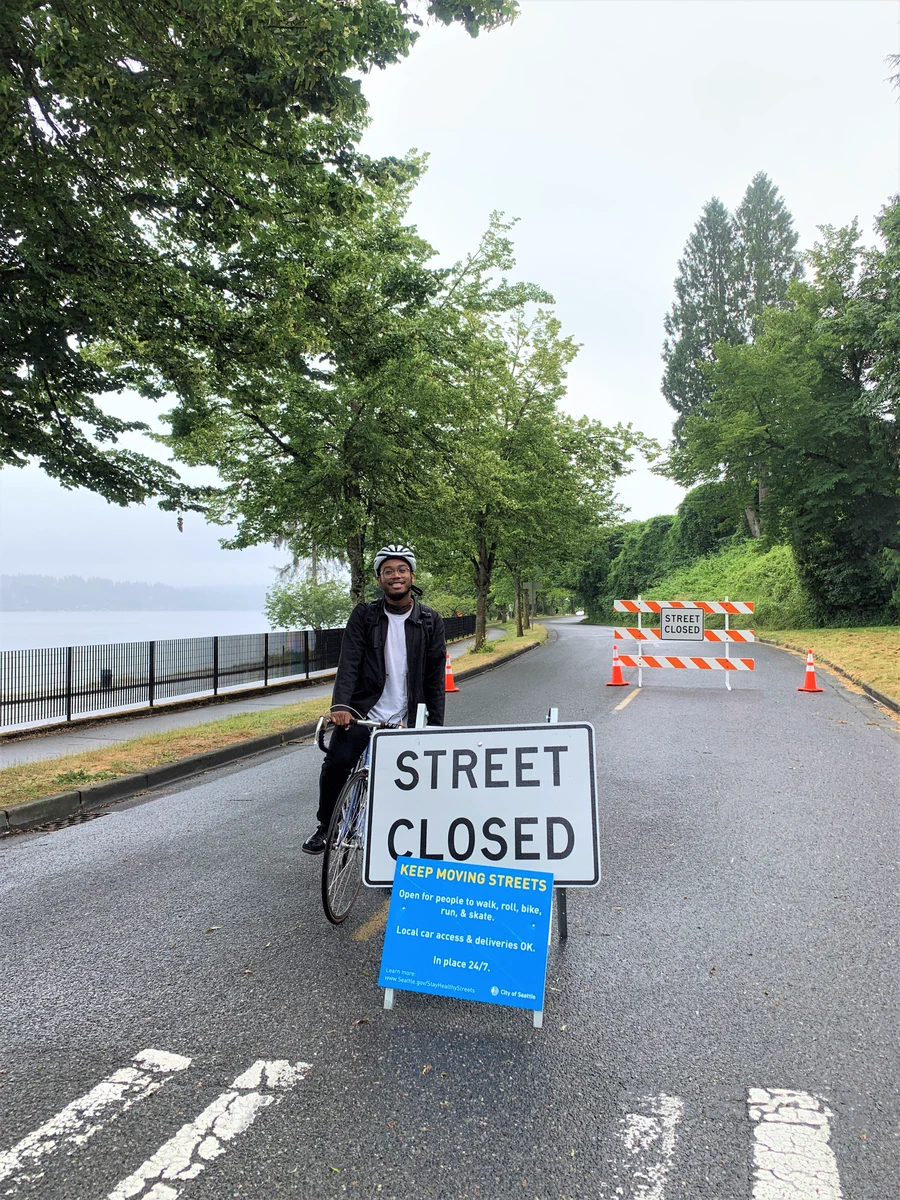 Ricky Reyes on his bicyle, paused on Lake Washington Blvd near the "Street Closed" sign marking the temporary street closure (to car traffic, that is -- but it's an OPEN street for walking, biking, skating, running, and rolling"

