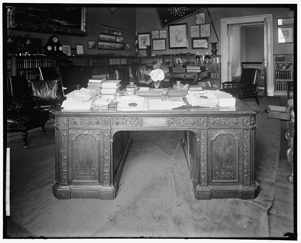 Title: Secretaire made from the timbers of the British Arctic ship Resolute and presented by Queen Victoria to the President of the United States. https://commons.wikimedia.org/w/index.php?title=Category:Resolute_desk&filefrom=Lincoln-bedroom-as-presidents-office-c1899.jpg#/media/File:Secretaire_made_from_the_timbers_of_the_British_Arctic_ship_"Resolute,"_and_presented_by_Queen_Victoria_to_the_President_of_the_United_States_LCCN99471788.jpg