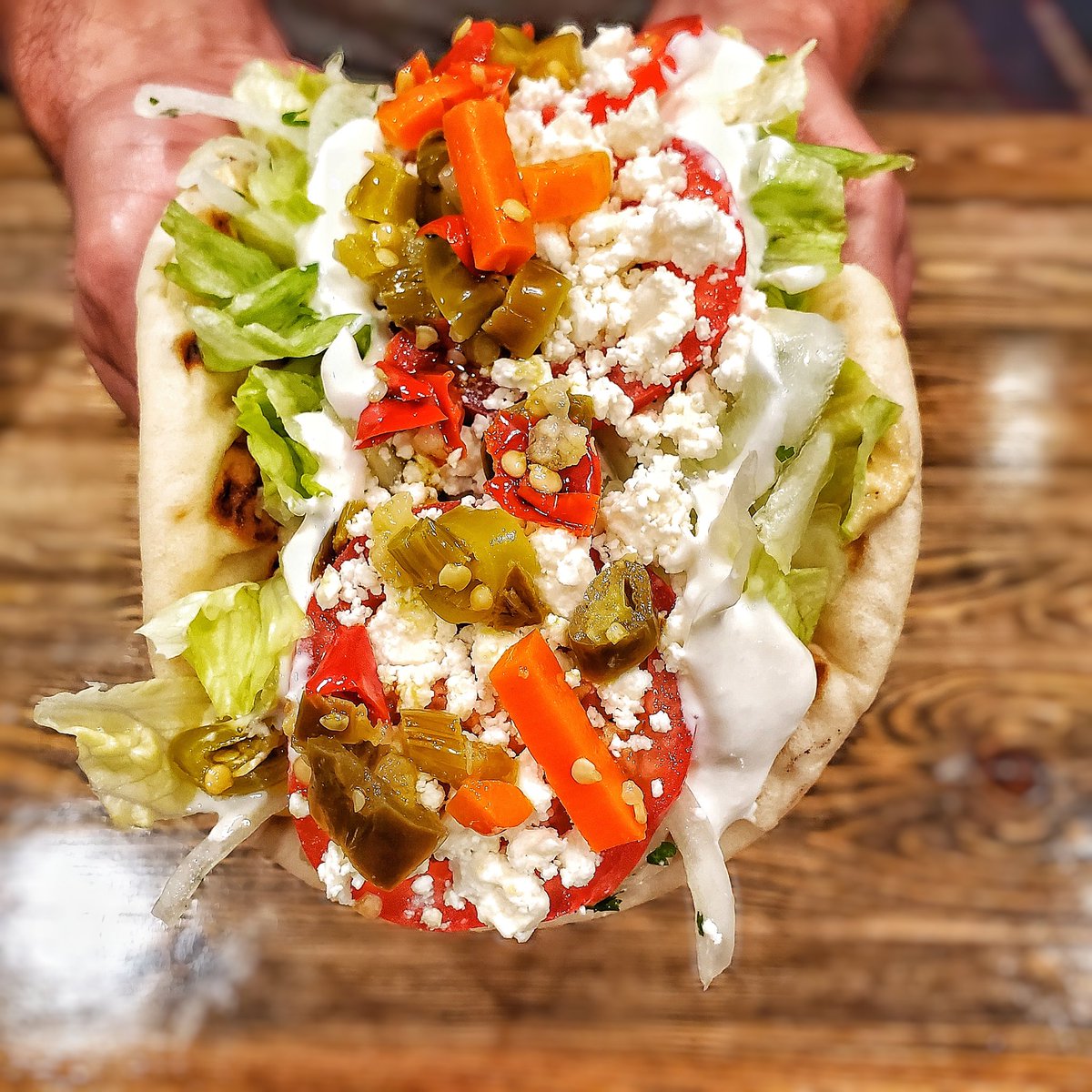 Spicy Veggie...creamy hummus, crisp lettuce, zesty probiotic Greek yogurt tzatziki, sliced onions, fresh parsley and ripe tomatoes, topped with local feta cheese and spicy giardiniera pepper medley, all wrapped up in a warm grilled pita bread.