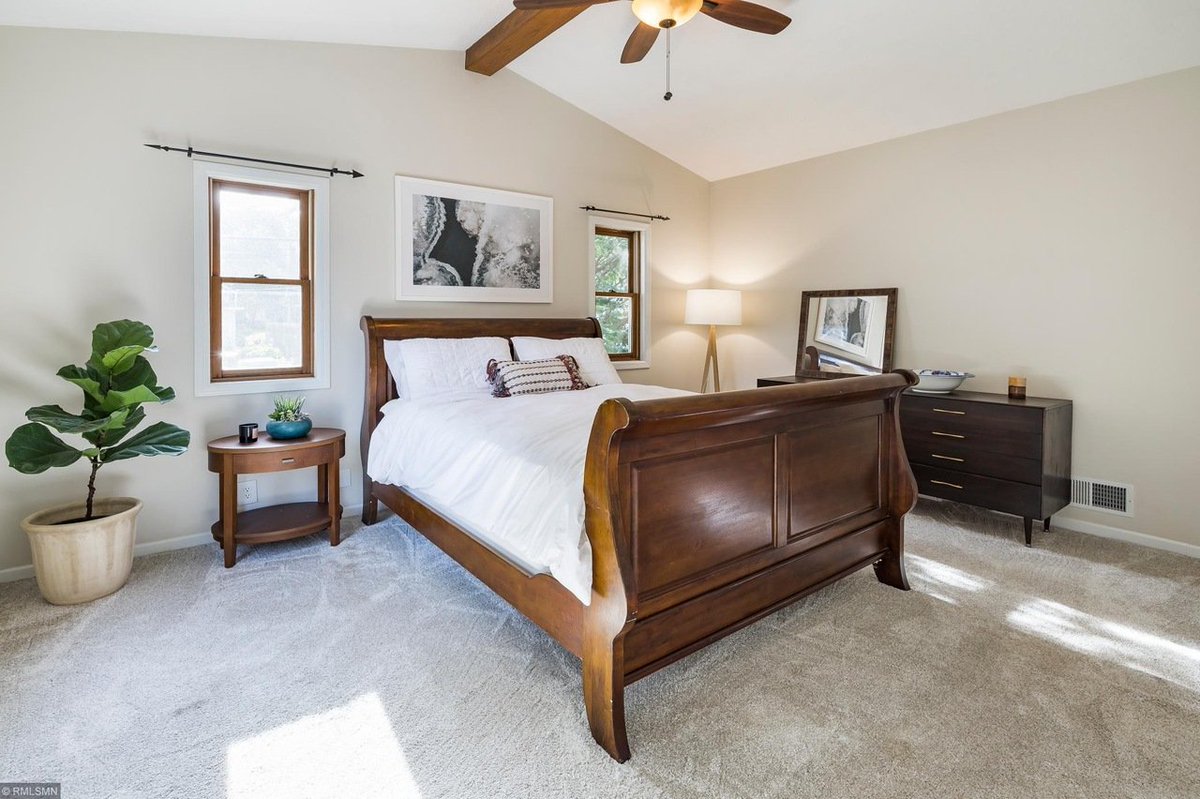 Jane: let's take a look at the master bedroom Tim: oh wow this is spacious. Tons of natural light. Those high ceilings are great. Jane: The beam gives it some of that midcentury modern flair, Heather. Heather: hmmm I do like the ceilings. Tim: Only downside is the carpet.