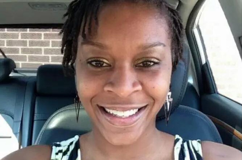Photo of Sandra Bland smiling while sitting in a car.