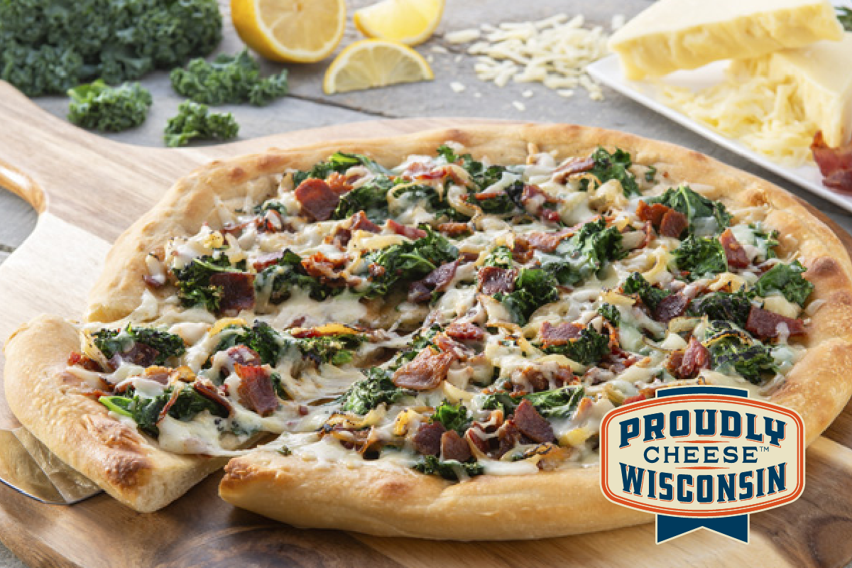 Take your pizzas to a whole new level by topping them with our artisanal Cheddar Gruyere from Wood River Creamery! This bacon, kale and caramelized onion pizza is a slice of heaven! Get the recipe here: bit.ly/3fQZsry.