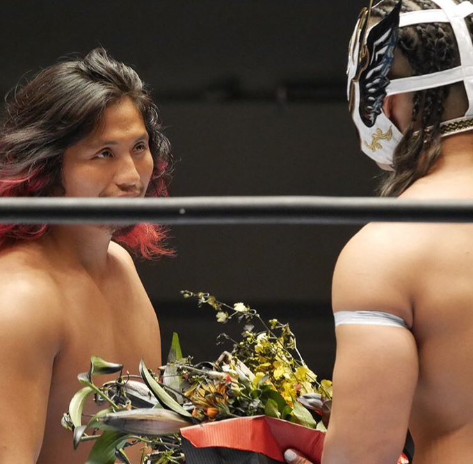 To start despy is backout here in a white mask (open backed this time with braids it's so good ;-;) and hiromu approaches the ring with......a guitar case? it's then that he presents Despy with flowers.....dead flowers