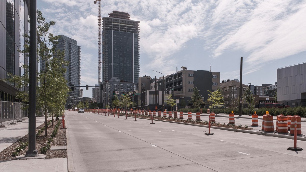 Seventh Avenue North with orange cones marking off the thin center media. New trees and shrubs planted in the median and planter strip at left.