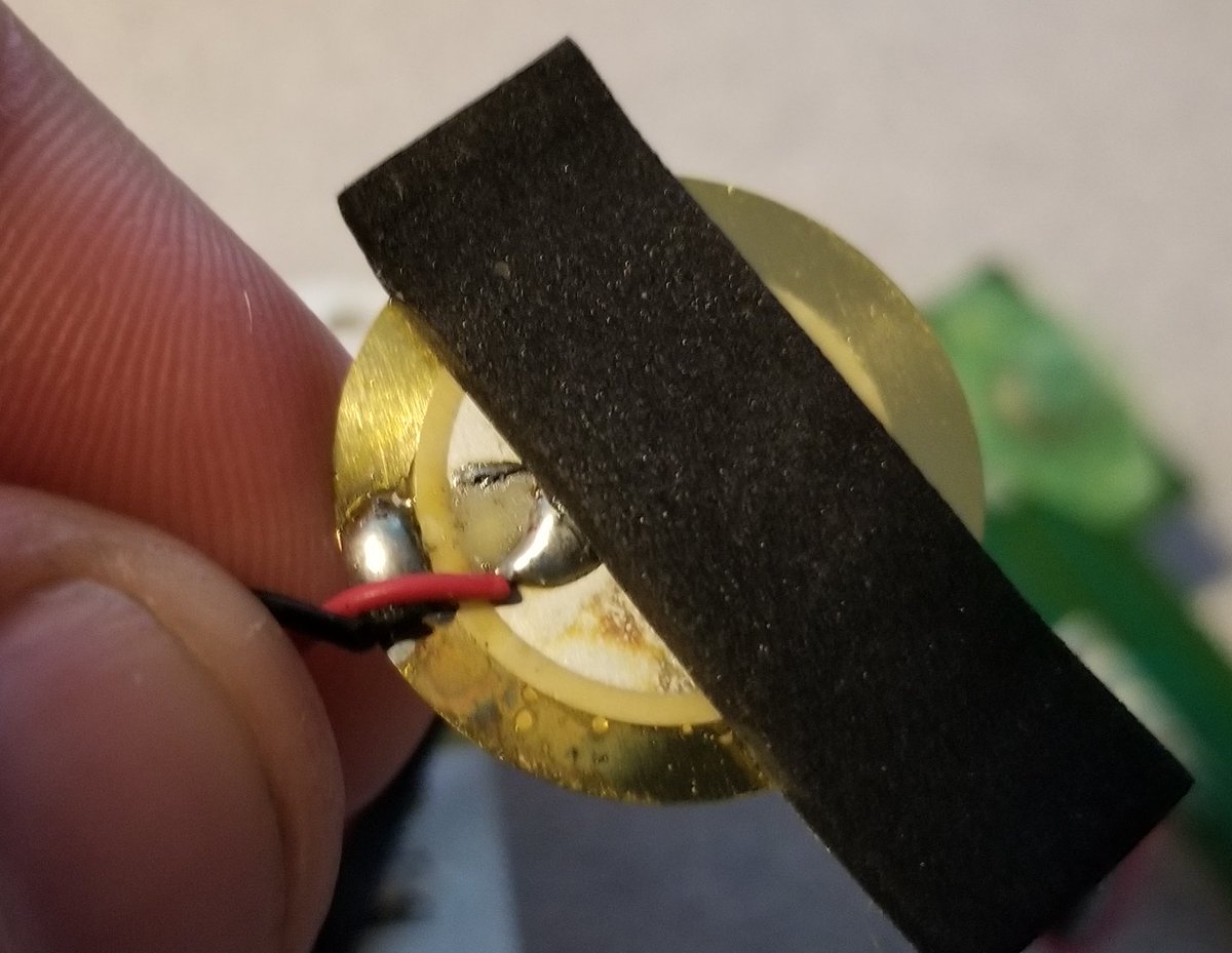 The final bit I can disassemble is that sensor.It's just a disc, I can't see any writing on it because the tape is on really tight and I don't want to damage it, and the other side is blank. So I think this is a piezo vibration sensor.