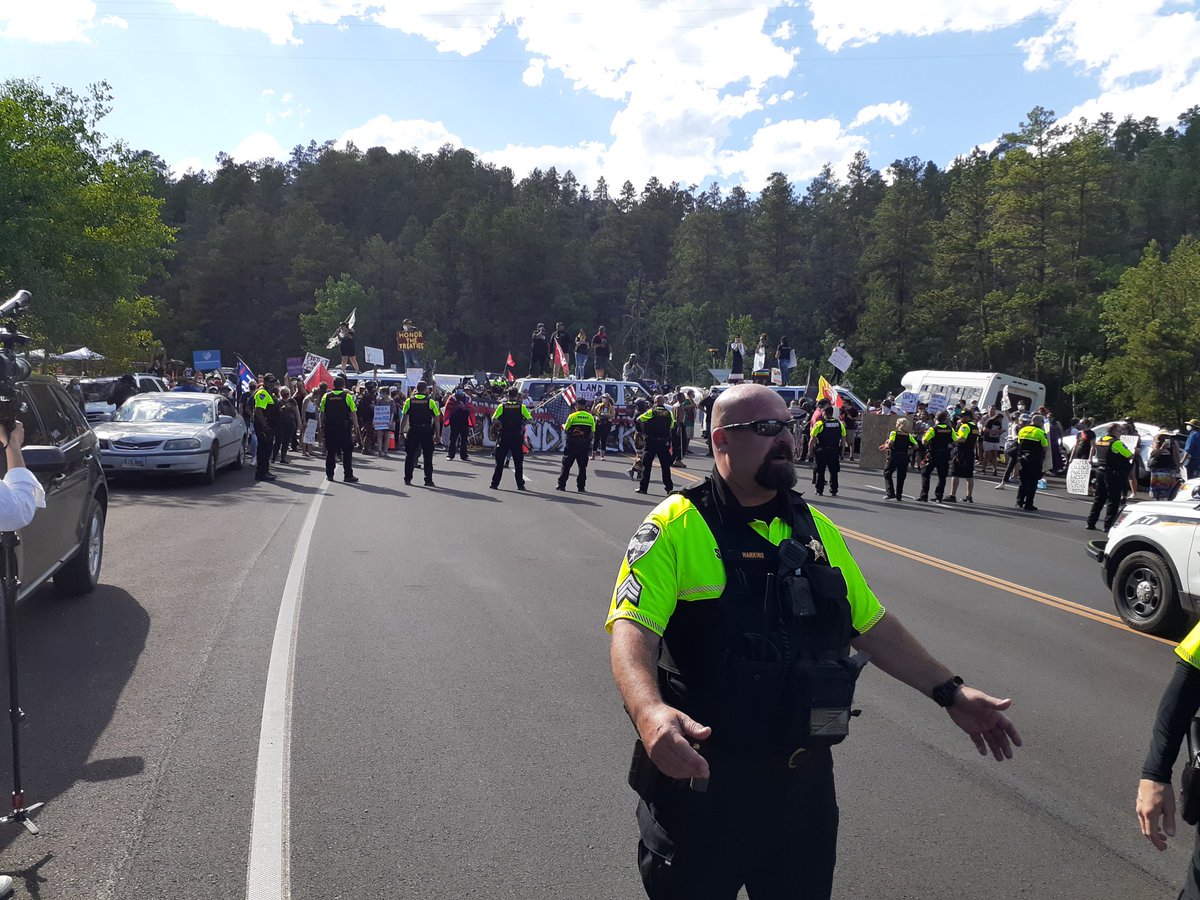 Deputies are now pushing us back about from the protest line blocking the entrance to Mount Rushmore.