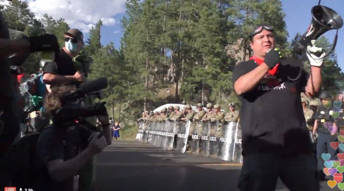 The protest leader's talking now. The National Guard's moving away the vans behind the line to clear the area. The protest leader says they're going to stand their ground and resist arrest.