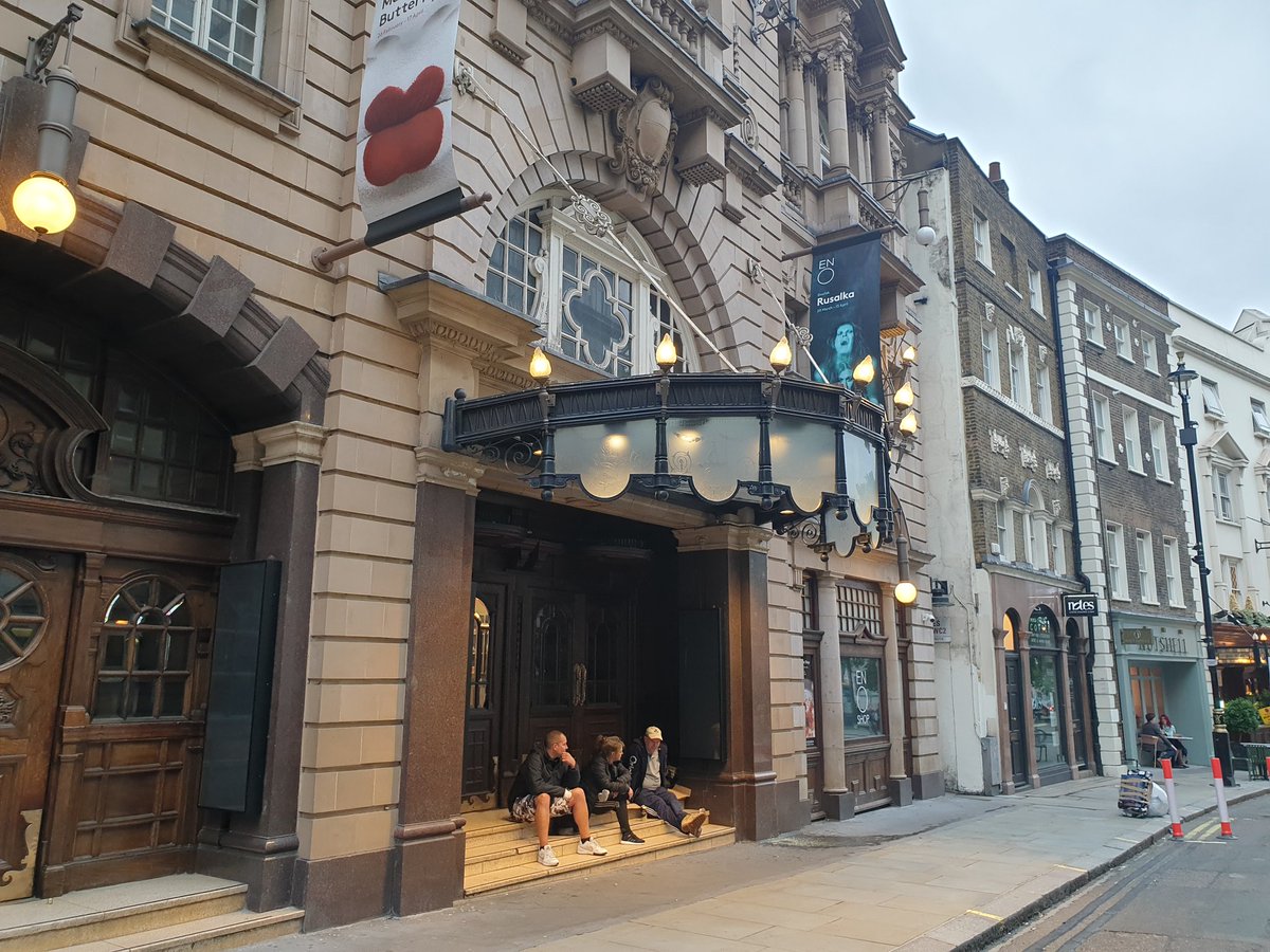 St Martin's Lane is dead. Banners for Madame Butterly and Rusalka flutter redundantly above the ENO while three sit on the steps outside.