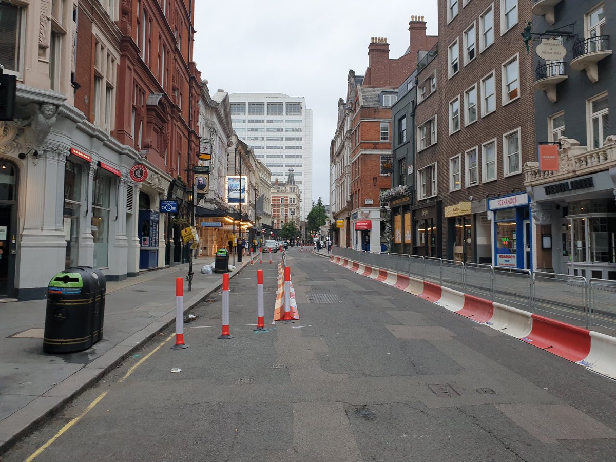 St Martin's Lane is dead. Banners for Madame Butterly and Rusalka flutter redundantly above the ENO while three sit on the steps outside.