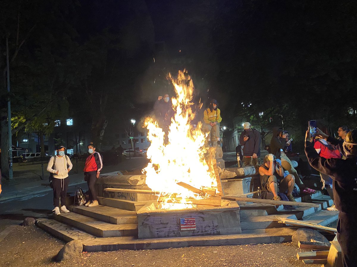 Crowd starts bonfire at base of old elk statue almost immediately