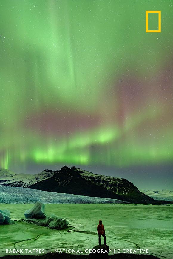 NatGeo's tweet photo. A vibrant aurora dances across the night sky in this otherworldly scene captured by photographer Babak Tafreshi at the edge of a glacial lake https://t.co/rmjtJX3pXK