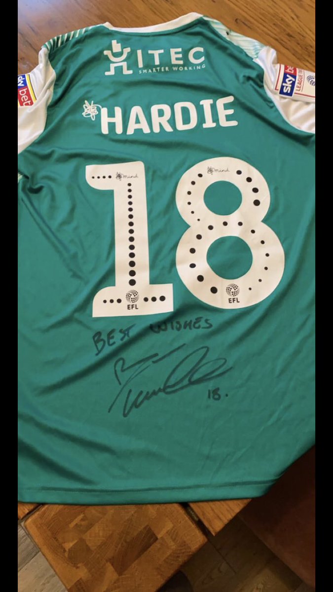 BluShop1870's tweet photo. The new top auction tonight for anyone who didn’t guess from the earlier badge is @Ryanhardie9 👏🏻

Ryan has kindly donated his Plymouth Argyle promotion winning away top for us, and has also signed it for the lucky winner.📝 https://t.co/V8Ws8DwAwm