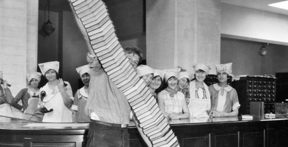 photo of many carrying a tall stack of books