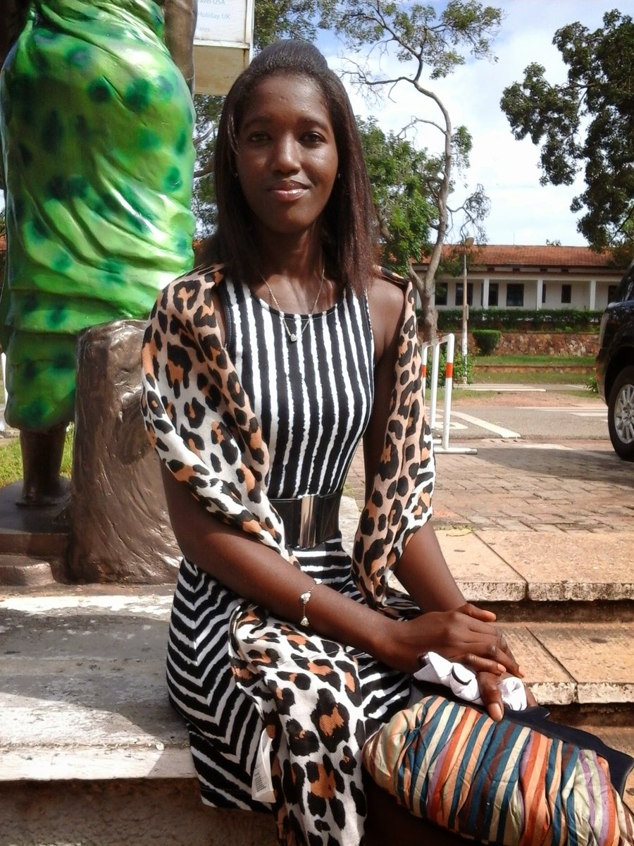 sweetpeagh's tweet photo. It's World Chocolate Day! I remember my days in Akuafo Hall. This hall was a gift from cocoa farmers to UG. To honour them, two statues were erected at the main entrance. I'm sitting by the statue of the woman who carries a basket of golden cocoa pods. 
https://t.co/hRuHTYgxAc https://t.co/R4psX4Y4uq