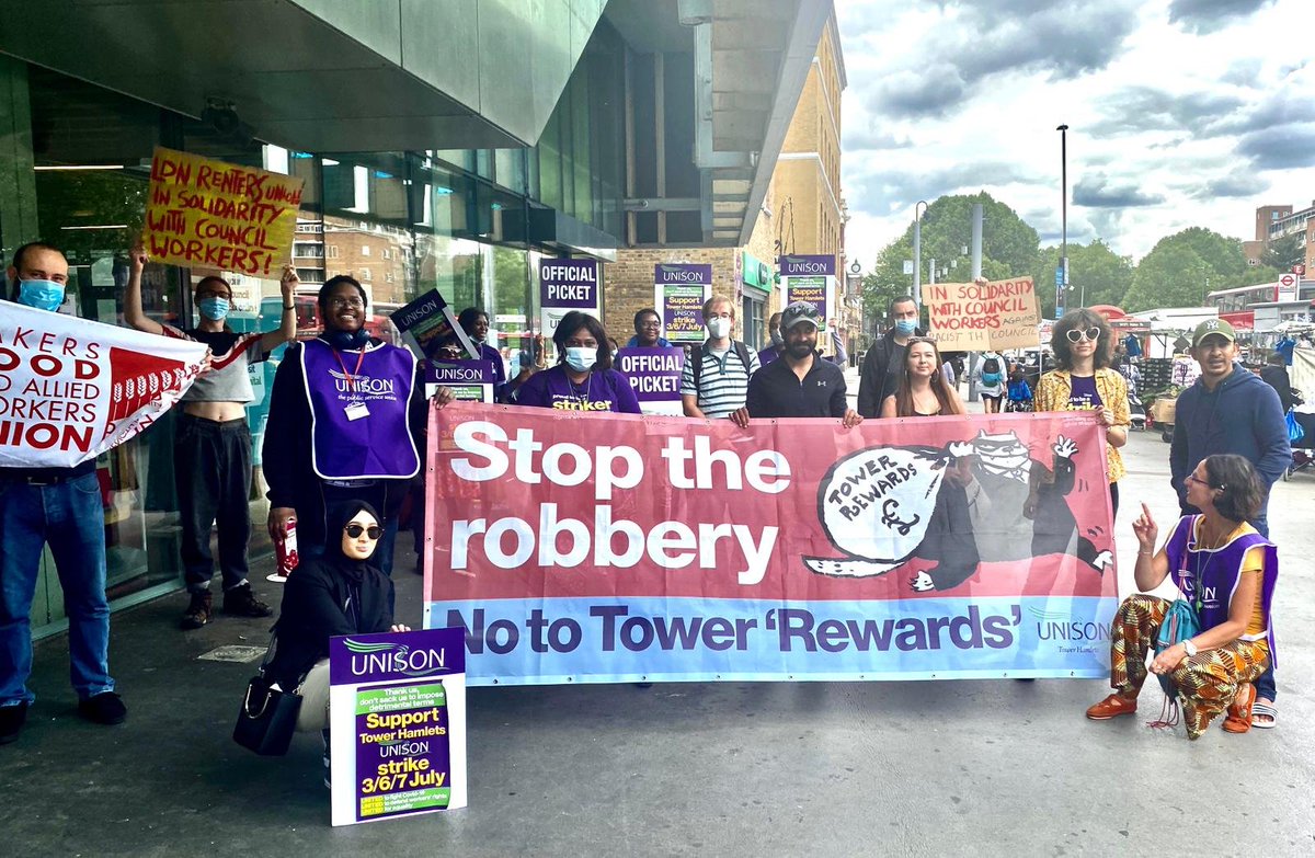 Striking UNISON workers on a picket in whitechapel road pose with a banner saying "Stop the Robbery: No to Tower 'Rewards'". Members of BFAWU and Tower Hamlets LRU also hold up signs.