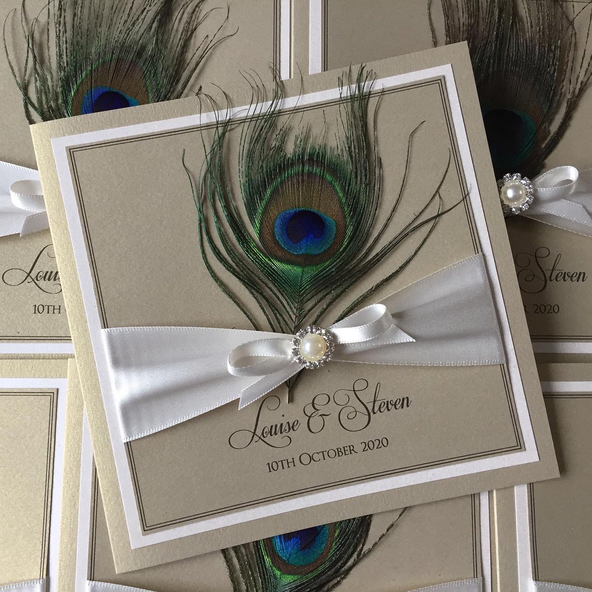 designerinvite's tweet photo. Beautiful peacock feathers on a pale gold pearlescent card finished with ivory bows &amp; Pearl &amp; diamante embellishment 
#wedding #stationery #invites #invitations #peacock #feathers #teal #gold #pearl #diamante #2020wedding #2021wedding #brideandgroom #mrandmrs #custom #engaged https://t.co/IIKwwYdzXL