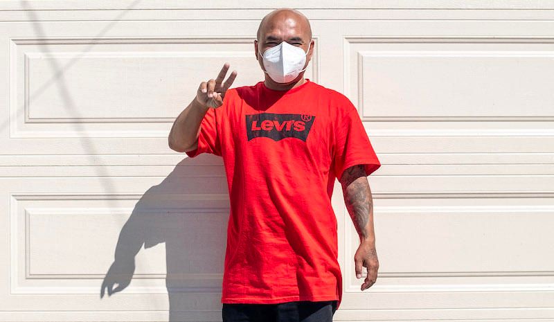 Chanthon Bun with a mask, smiling and showing a peace sign