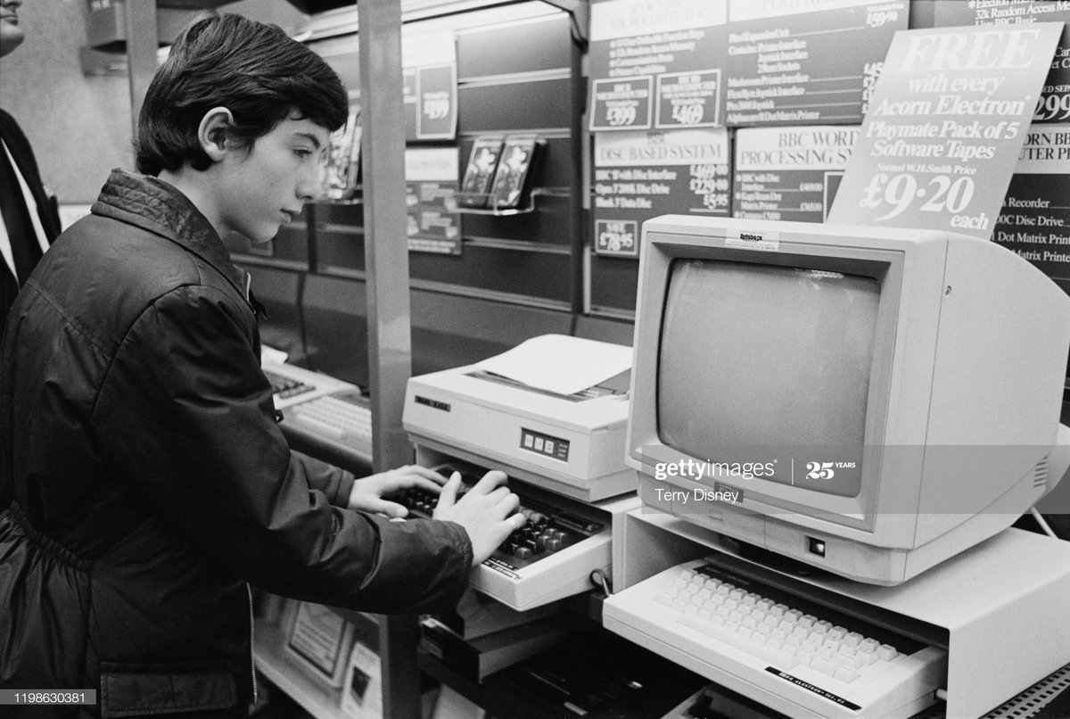 “A young boy looking at Acorn Electron computer and monitor in a WHSmith shop in Waterloo, London, UK, 6th December 1984.”