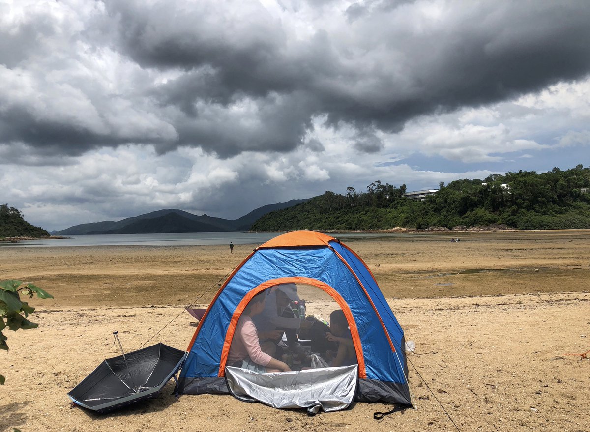 ThePointTaken's tweet photo. #VisualHK: A family rests inside a tent on Wu Kai Sha beach as clouds fill the sky. (📷Edmond Tang / China Daily) https://t.co/3rvhH2eYMX